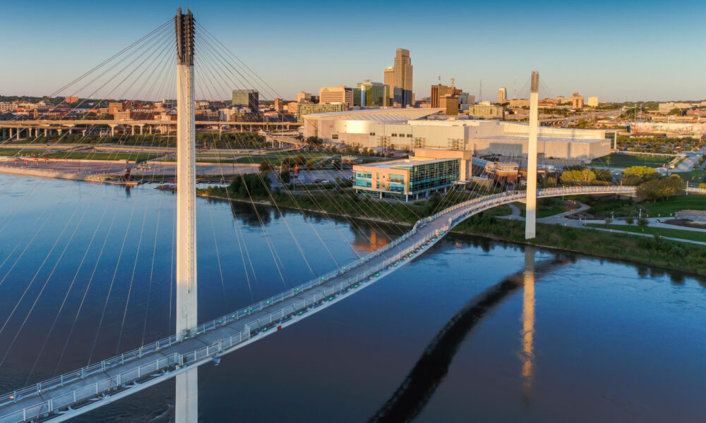 Aerial view of the Bob Kerrey Pedestrian Bridge spanning the Missouri River with downtown Omaha in the background.