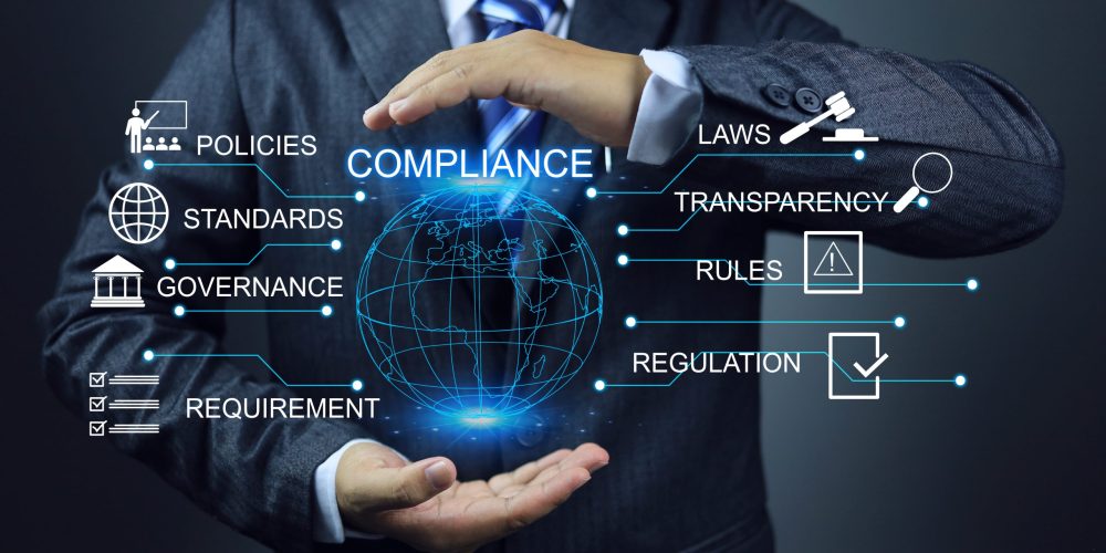 Businessman holding digital globe with compliance terms and icons