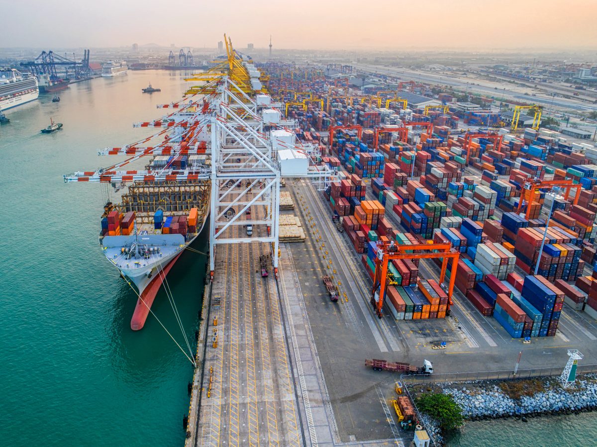 Aerial view of a busy shipping port with cargo containers and cranes