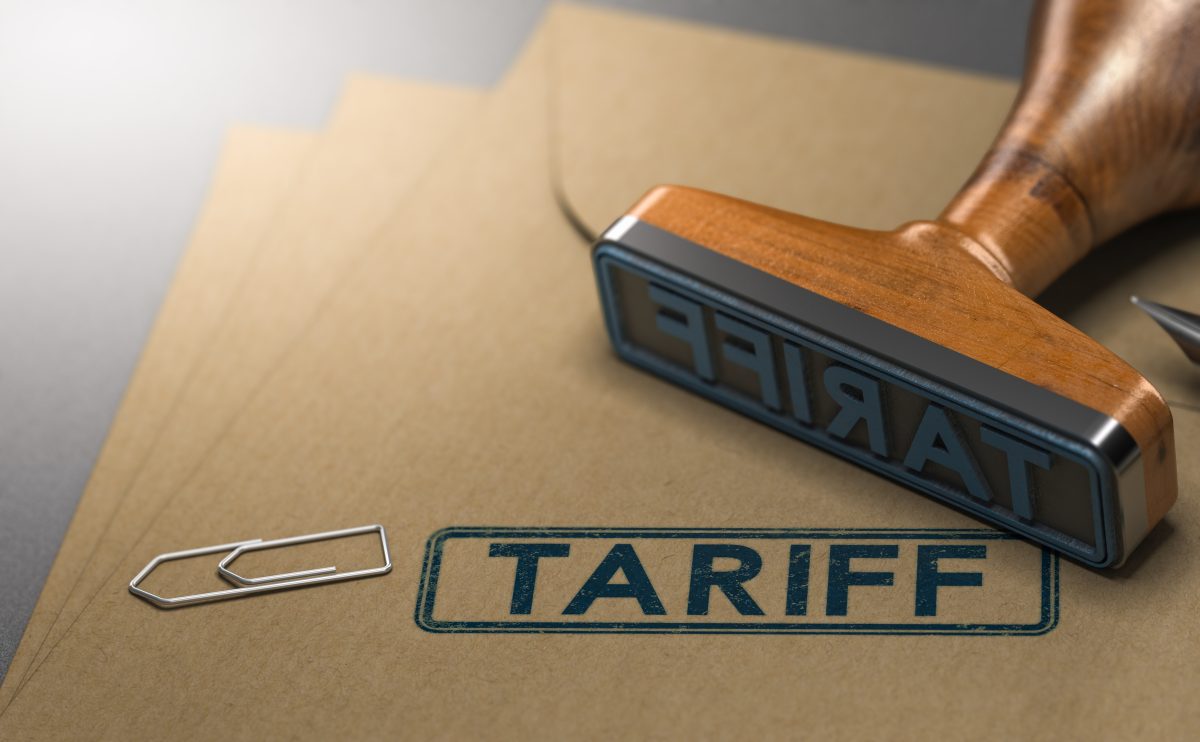 Wooden stamp imprinting the word "TARIFF" on a brown folder